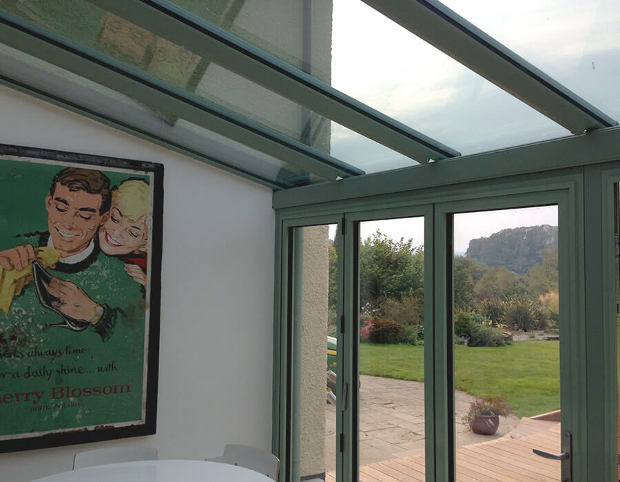Green uPVC conservatory with glass roof interior view