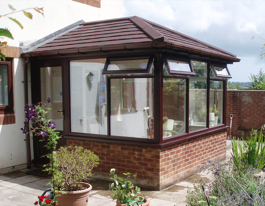 Rosewood effect uPVC conservatory with a red tiled roof