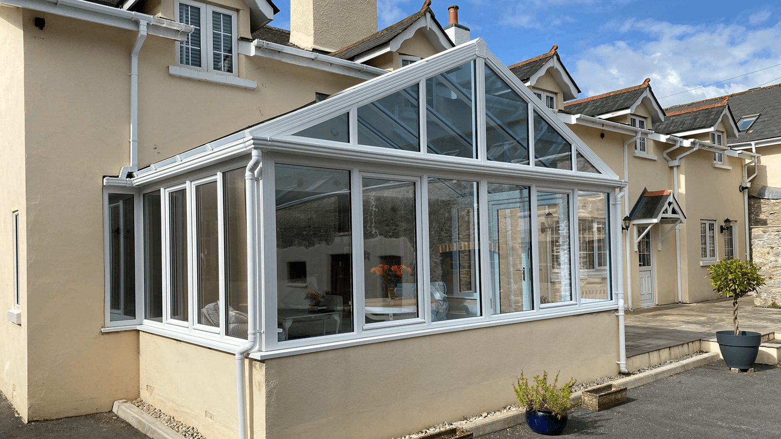 white upvc conservatory with a glass roof on a cream coloured house