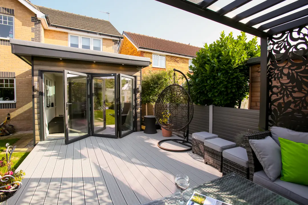 Alumina aluminium bifold doors fully open onto a modern patio area, seamlessly connecting the home’s interior with the outdoor space.