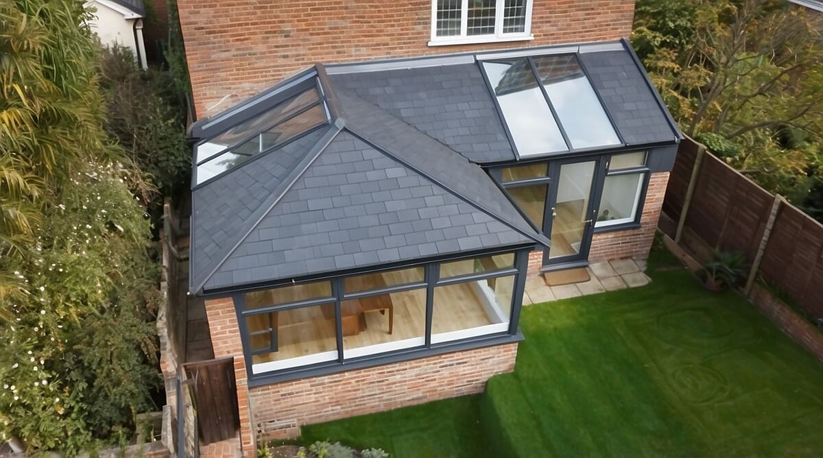 L-shaped conservatory in Newton Abbot with anthracite grey uPVC frames and hybrid solid-glass roof